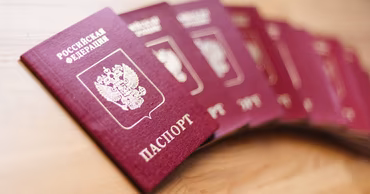 A stack of Russian Federation passports on a wooden surface.