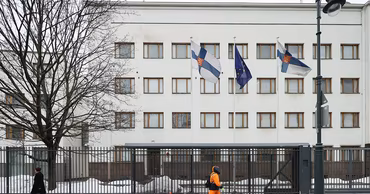 A building with Finnish and European Union flags flying in front of it.
