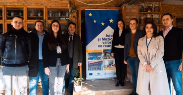 A group of people standing in front of a banner promoting cultural heritage and museums.