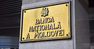 The golden plaque of the National Bank of Moldova on a building wall.