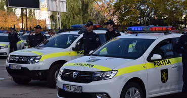 Moldovan police officers standing next to their patrol cars.