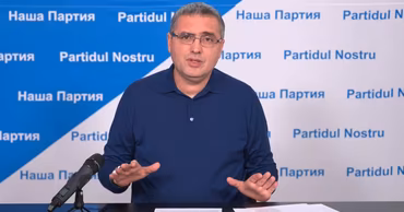 Renato Usatii speaking at a press conference with the Partidul Nostru logo in the background.