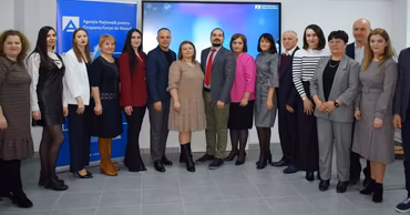 A group of professionals from the National Employment Agency of Moldova standing together in an office.
