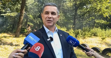 Anatolie Nosatii speaking to journalists with microphones in front of him.