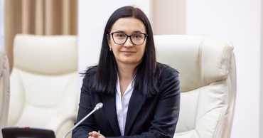 Anastasia Uceretnîi sitting at a conference table in an office setting.