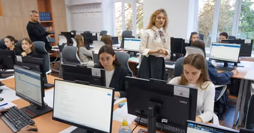 Students and a teacher in a modern computer classroom in Moldova.
