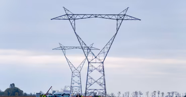 Construction workers and vehicles at the site of high-voltage power line towers in Moldova.