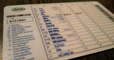 A close-up view of a Moldovan driver's license card showing various vehicle categories.