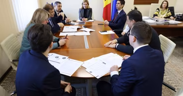 Moldovan government officials and representatives in a formal meeting around a conference table.