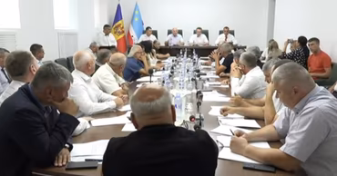 Deputies of the Gagauz People's Assembly sitting at a conference table during a meeting.