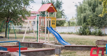 A playground with a slide and swings in a kindergarten yard in Balti.