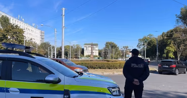 A Moldovan police officer standing next to a patrol car in Chisinau.