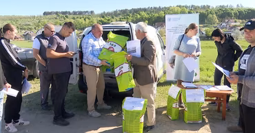 People distributing bags of seeds and agricultural supplies at an outdoor event in Moldova.