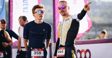 Two male athletes in professional sportswear standing at a duathlon competition.