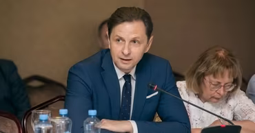 Vladislav Kulminski sitting at a conference table during a meeting.