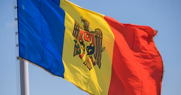 The national flag of Moldova waving against a clear blue sky.