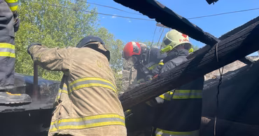 Moldovan firefighters extinguishing a fire on the roof of a building.