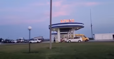 A gas station in Moldova at dusk with cars refueling.