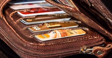 A brown leather wallet filled with various credit and debit cards.