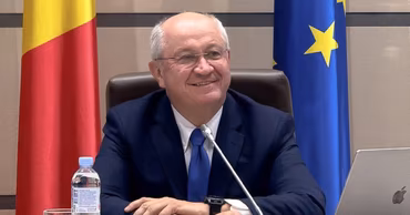 Igor Grosu sitting at a table with Moldovan and European Union flags in the background.