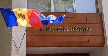 The building of the Ministry of Justice of Moldova with the national and EU flags.