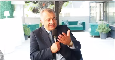 Ion Chicu speaking into a microphone during an event.