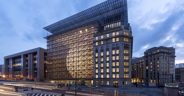 The Europa building in Brussels at dusk, the seat of the Council of the European Union.