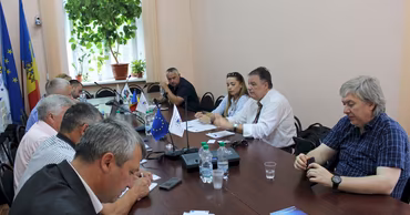 A group of people sitting at a conference table during a CALM meeting in Moldova.