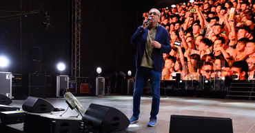 Renato Usatii speaking on a stage at an outdoor event.