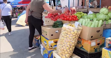 A street market stall in Moldova with fresh vegetables and fruits for sale.