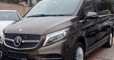 A brown Mercedes-Benz minivan parked on a paved surface.
