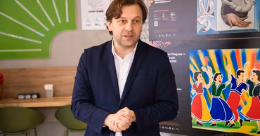 Dumitru Vangheli standing in a room with posters in the background.