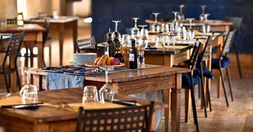 A well-set dining table in a restaurant with wooden furniture and tableware.