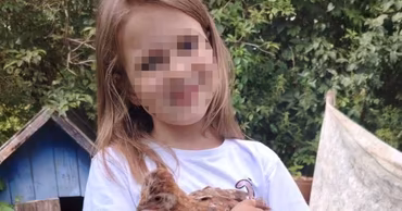 A young girl holding a small chicken, used for a missing person search.