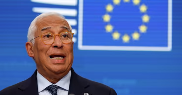 Antonio Costa speaking in front of a European Union flag.