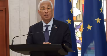 Antonio Costa speaking at a podium with European Union flags in the background.