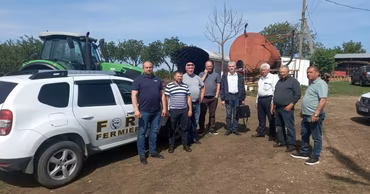A group of farmers standing next to a car with the Forța Fermierilor logo.