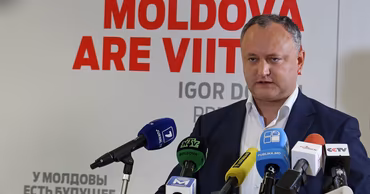 Igor Dodon speaking at a press conference with microphones in front of him.