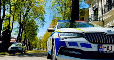 A Moldovan police car parked on a street in a city.