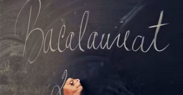 A hand writing the word Bacalaureat on a blackboard.