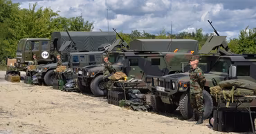 Moldovan military vehicles and soldiers in camouflage uniforms during a training exercise.