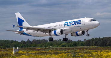 A FlyOne passenger airplane landing at an airport.
