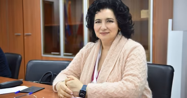 Tatiana Batin sitting at a desk in an office setting.