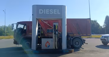 A truck refueling with diesel at a gas station.