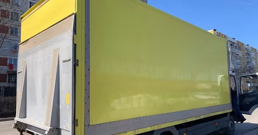 A yellow heavy truck parked on a city street.