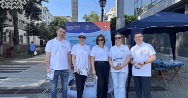 A group of people in white shirts standing in front of a CNSM banner.