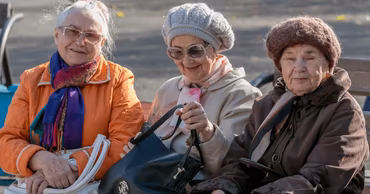 Three elderly women sitting on a park bench in Moldova.