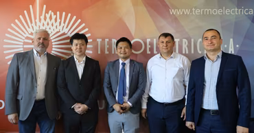 A group of five men standing in front of a Termoelectrica branded backdrop.