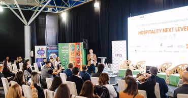 A speaker addressing an audience at a hospitality industry conference in Moldova.