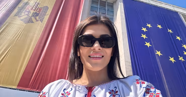 Anastasia Taburceanu taking a selfie in front of the Moldovan and European Union flags.